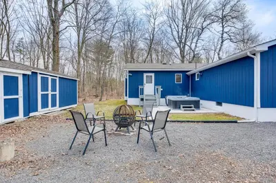 a patio with chairs and a table in front of a blue building at Happy Place by the Lake with Fire Pit Walk to Beach in Pocono Lake