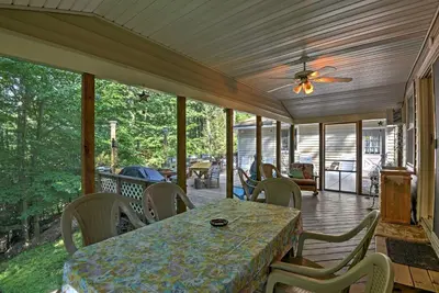 a screened in porch with a table and chairs at 1 Mi to Lake Wallenpaupack Pocono Mountain Home! in Greentown