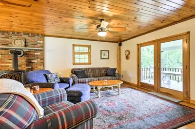 a living room with couches and a wooden ceiling at Thompson Home with Deck and Pond, 8 Mi to Elk Mountain in Thompson