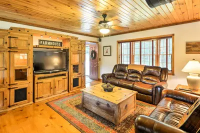 a living room with leather furniture and a flat screen tv at Thompson Home with Deck and Pond, 8 Mi to Elk Mountain in Thompson