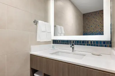 a bathroom with a sink and a mirror at Courtyard by Marriott New York Manhattan/Chelsea in New York