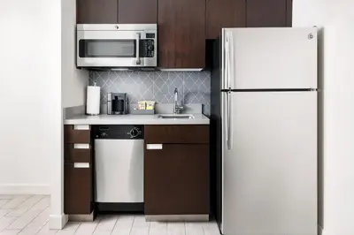 a kitchen with a white refrigerator and a microwave at Residence Inn by Marriott New York Downtown Manhattan/World Trade Center Area in New York