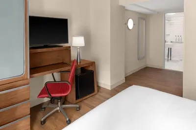 a room with a red chair and a desk with a television at Fairfield Inn by Marriott New York Manhattan/Financial District in New York