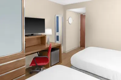 a hotel room with a bed and a desk with a television at Fairfield Inn by Marriott New York Manhattan/Financial District in New York