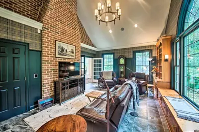 a living room with leather furniture and a brick wall at Extravagant Atglen Manor with Private 60-Acre Land! in Atglen