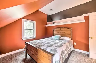 a bedroom with an orange wall with a bed in it at Extravagant Atglen Manor with Private 60-Acre Land! in Atglen