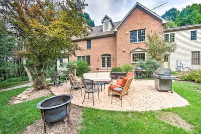 a patio with chairs and a grill in front of a house at Extravagant Atglen Manor with Private 60-Acre Land! in Atglen