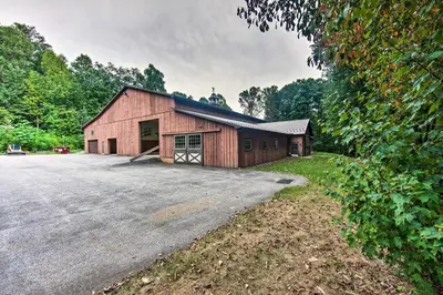 a large red barn with a garage at Extravagant Atglen Manor with Private 60-Acre Land! in Atglen