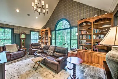 a living room with leather furniture and a chandelier at Extravagant Atglen Manor with Private 60-Acre Land! in Atglen