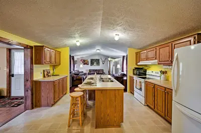 a kitchen with wooden cabinets and a white refrigerator at 180-Acre Farm The Lodge in Klingerstown! in Klingerstown
