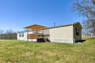 a large white building with a porch on a grass field at 180-Acre Farm The Lodge in Klingerstown! in Klingerstown
