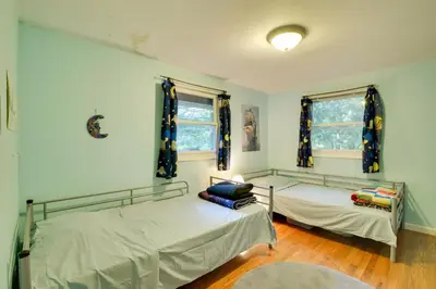 two beds in a room with two windows at Secluded Stroudsburg Home - 5 Mi to Ski Resort in Stroudsburg