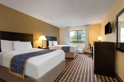 a hotel room with two beds and a window at Days Inn by Wyndham Hillsborough in Hillsborough