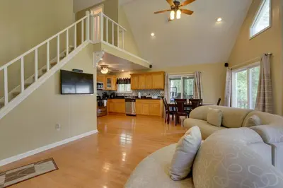 a living room with a couch and a tv and a kitchen at Pools, Hot Tub and More Bushkill Mountain Getaway! in Sandyville