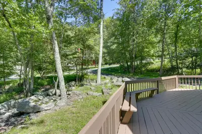 a wooden deck with a bench next to a garden at Pools, Hot Tub and More Bushkill Mountain Getaway! in Sandyville