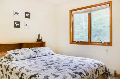 a bedroom with a bed and a window at Walk to Beach Beautiful Lake Naomi Retreat! in Pocono Pines