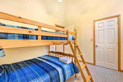 a bedroom with two bunk beds and a ladder at Walk to Beach Beautiful Lake Naomi Retreat! in Pocono Pines
