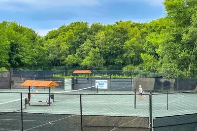 two tennis courts with two people playing tennis at Walk to Beach Beautiful Lake Naomi Retreat! in Pocono Pines