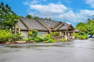 a large house with a parking lot in front of it at Walk to Beach Beautiful Lake Naomi Retreat! in Pocono Pines