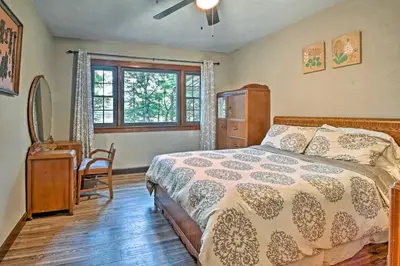 a bedroom with a bed and a desk and a window at Historic Stone Cottage with Firepit-Walk to Lily Lake in Wapwallopen