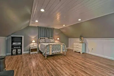 a bedroom with a bed and a wooden floor at Historic Stone Cottage with Firepit-Walk to Lily Lake in Wapwallopen