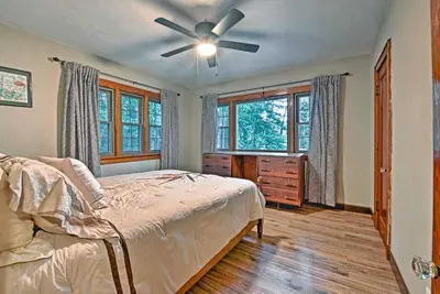 a bedroom with a bed and a ceiling fan at Historic Stone Cottage with Firepit-Walk to Lily Lake in Wapwallopen