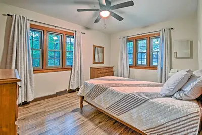 a bedroom with a bed and a ceiling fan at Historic Stone Cottage with Firepit-Walk to Lily Lake in Wapwallopen