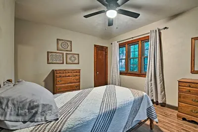 a bedroom with a bed and a ceiling fan at Historic Stone Cottage with Firepit-Walk to Lily Lake in Wapwallopen