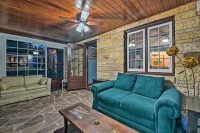 a living room with a couch and a table at Historic Stone Cottage with Firepit-Walk to Lily Lake in Wapwallopen