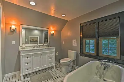 a bathroom with a tub and a toilet and a sink at Historic Stone Cottage with Firepit-Walk to Lily Lake in Wapwallopen