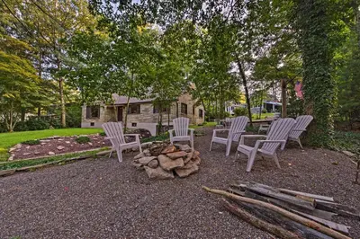 a group of chairs sitting around a fire pit at Historic Stone Cottage with Firepit-Walk to Lily Lake in Wapwallopen