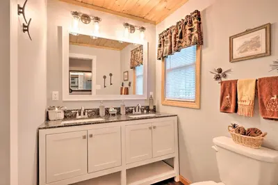 a bathroom with a sink and a mirror at Relaxing Eagle Rock Resort Home - 1 Block to Lake! in Hazleton