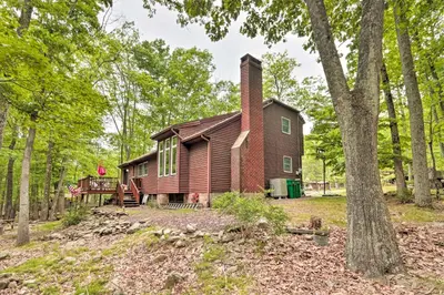 an old house with a chimney in the woods at Relaxing Eagle Rock Resort Home - 1 Block to Lake! in Hazleton