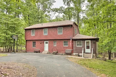 a red house with a driveway in front of it at Relaxing Eagle Rock Resort Home - 1 Block to Lake! in Hazleton