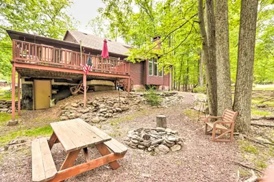 a log cabin with a picnic table and a fire place at Relaxing Eagle Rock Resort Home - 1 Block to Lake! in Hazleton