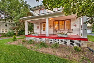 a house with a red porch with a bench on it at Whimsical Lancaster Home - 4 Mi to Sight and Sound in Lancaster