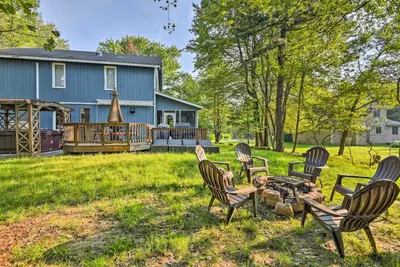 a group of chairs sitting on a lawn in front of a house at Lake Harmony Resort Home with Deck and Fire Pit! in Lake Harmony