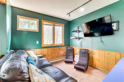 a living room with a couch and a flat screen tv at Lake Harmony Resort Home with Deck and Fire Pit! in Lake Harmony