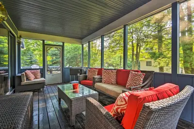 a screened in porch with a couch and chairs at Lake Harmony Resort Home with Deck and Fire Pit! in Lake Harmony