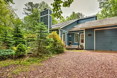 a house with a blue garage and a driveway at Lake Harmony Resort Home with Deck and Fire Pit! in Lake Harmony
