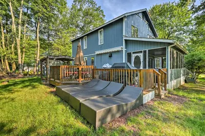 a home with a large deck and a house at Lake Harmony Resort Home with Deck and Fire Pit! in Lake Harmony