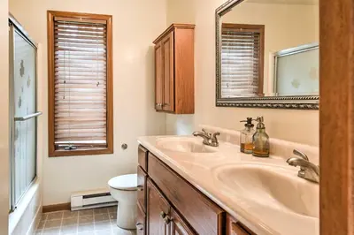 a bathroom with a sink and a toilet and a mirror at Lake Harmony Resort Home with Deck and Fire Pit! in Lake Harmony