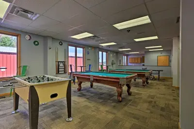 a room with three pool tables in it with windows at Creekside Arrowhead Lake House with Dock and Canoe! in Pocono Lake