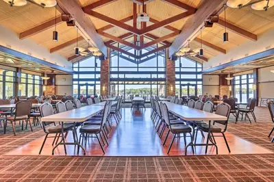 a dining hall with tables and chairs and windows at Creekside Arrowhead Lake House with Dock and Canoe! in Pocono Lake