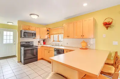 a kitchen with wooden cabinets and a counter top at Pocono Retreat Access to Community Lake and Beach! in Albrightsville