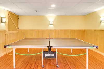 a ping pong table in a room with wooden floors at Pocono Retreat Access to Community Lake and Beach! in Albrightsville