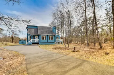 a blue house in the middle of a road at Pocono Retreat Access to Community Lake and Beach! in Albrightsville