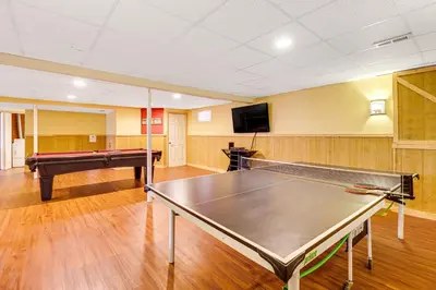 a room with a ping pong table and a tv at Pocono Retreat Access to Community Lake and Beach! in Albrightsville