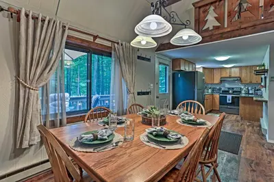 a kitchen and dining room with a wooden table and chairs at Pocono Lake House Near Skiing and Kalahari Resort! in Pocono Lake