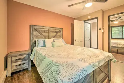 a bedroom with a bed and a dresser and a window at Hot Tub and Fire Pit Waterfront Lake Harmony Home in Lake Harmony